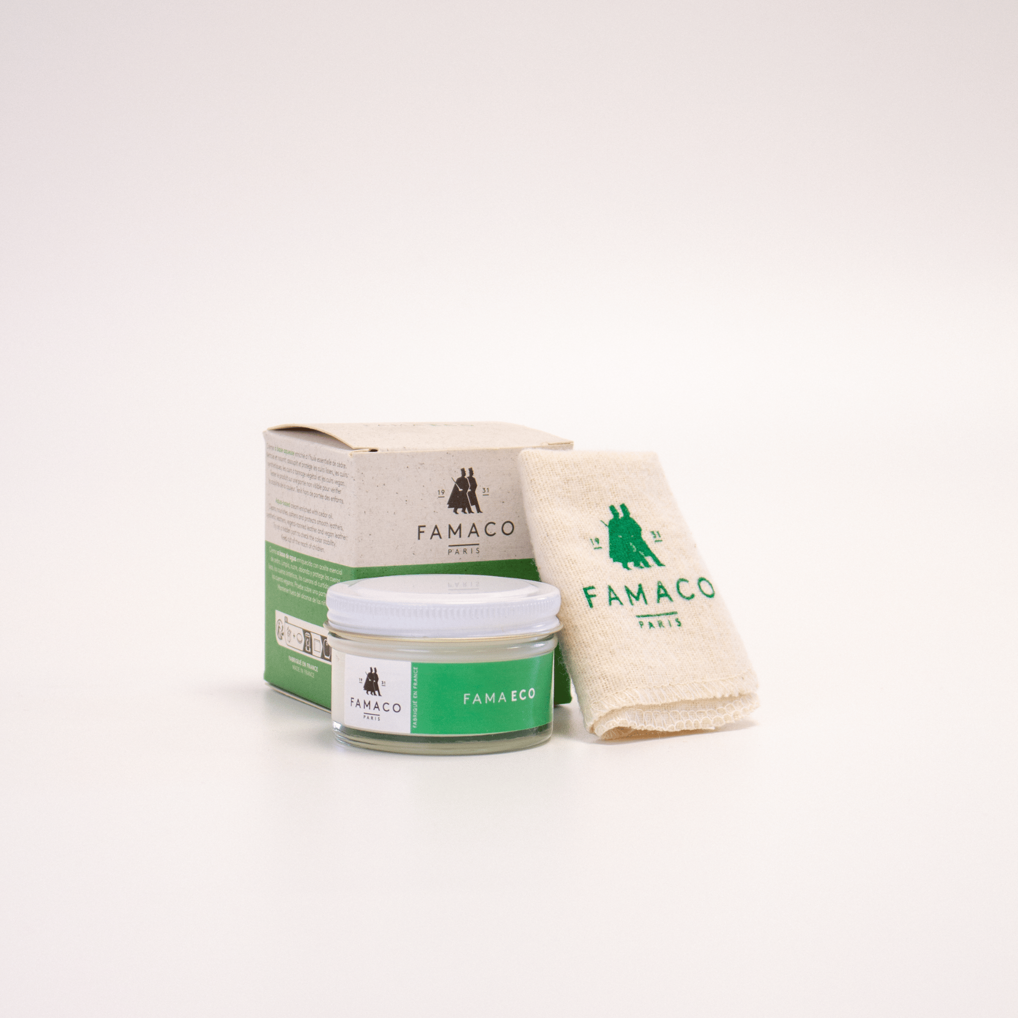 Le pommadier FAMA ECO de FAMACO est placé à côté du chiffon doux fourni, avec son emballage en carton disposé derrière, sur un fond blanc.