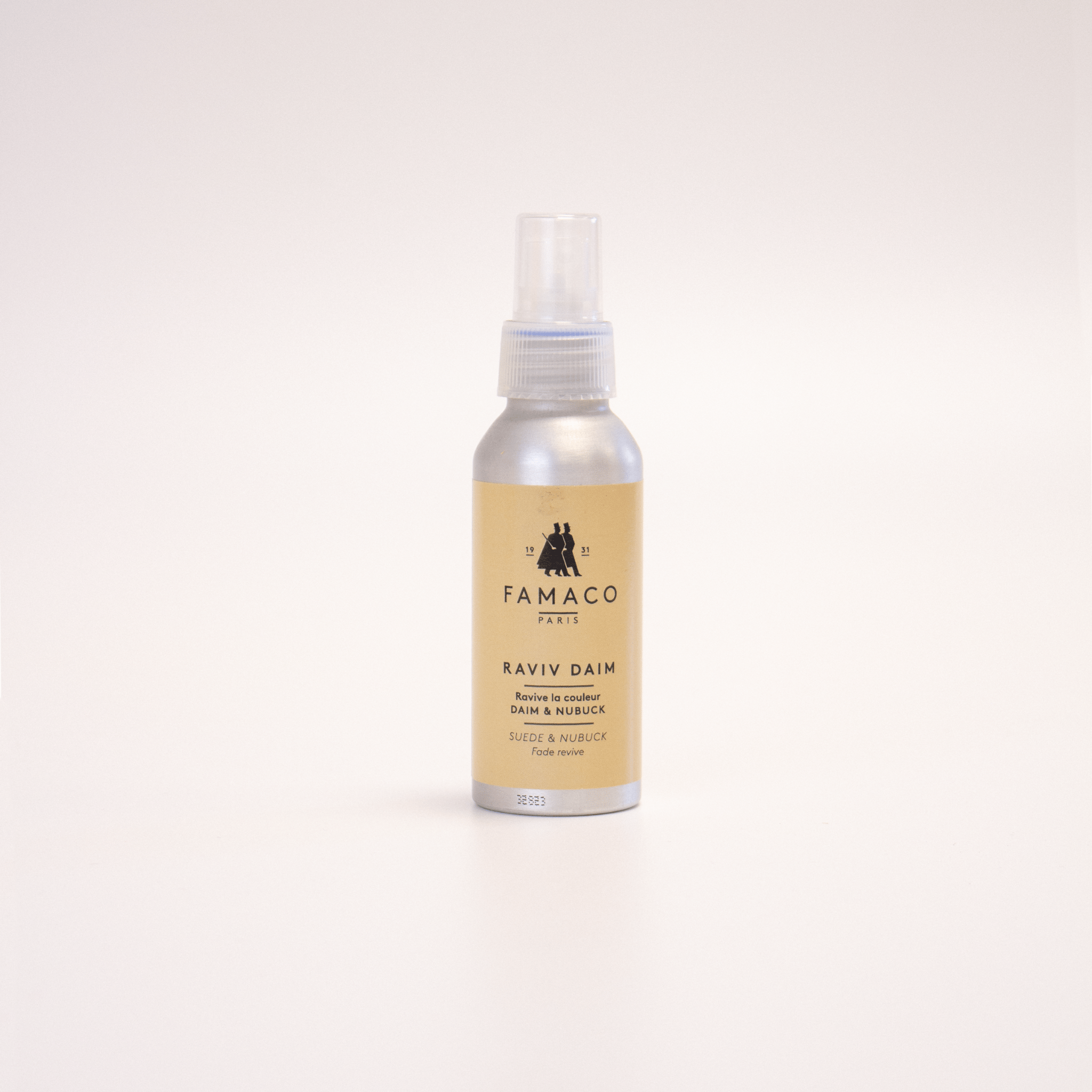 Le spray RAVIV'DAIM de FAMACO, conçu pour raviver la couleur des chaussures en daim, suède et nubuck, est posé sur un fond blanc.