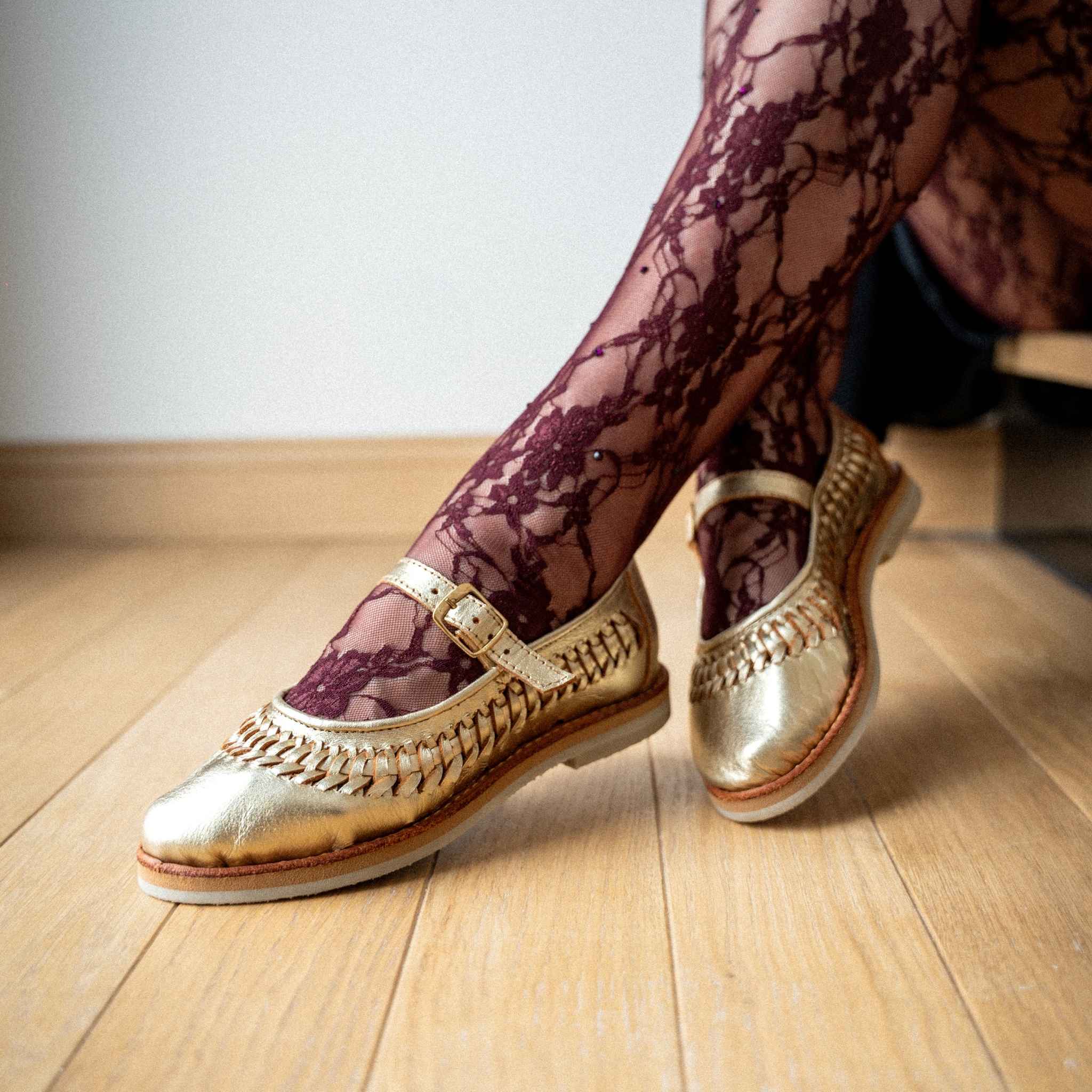 Ballerine Sofia Champagne portée avec un collant bordeaux en dentelle