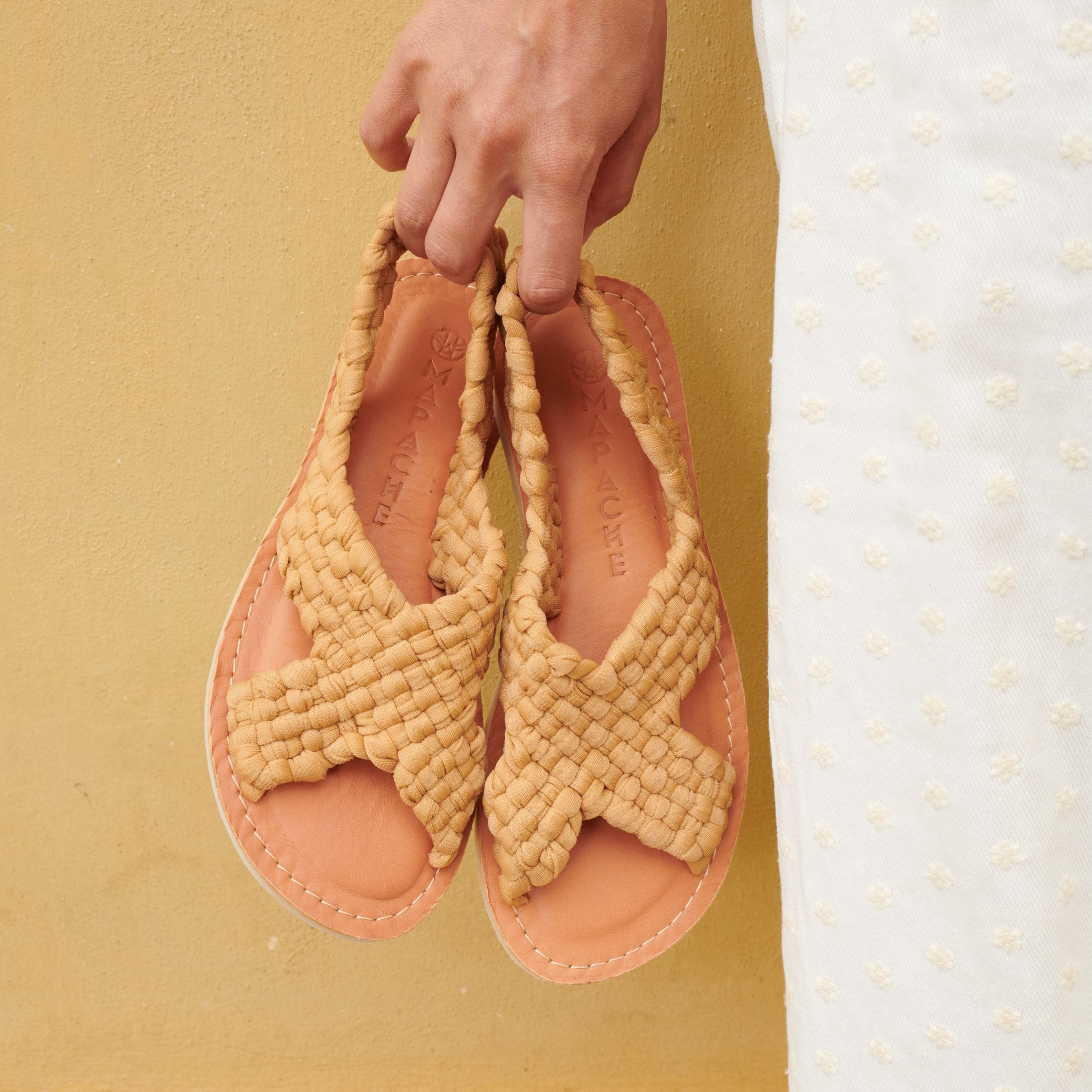 Sandales Zula Nude au tressage en nylon croisé de couleur camel, tenues à la main par Laura.